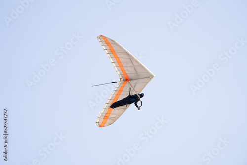 Pilot of a flexible wing hang glider with his body supported by a harness