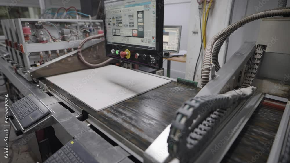 An industrial printer in a porcelain tile factory. The printer applies ...