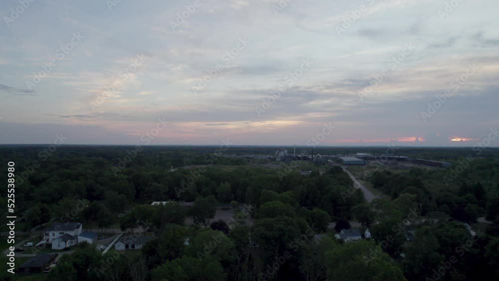 Aerial drone forward moving shot over an old lumber mill during sunset over the horizon. Aerial drone forward moving shot over an old lumber mill during sunset over the horizon.