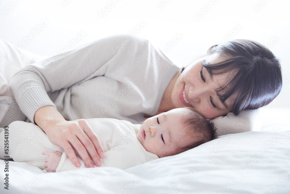 眠る赤ちゃんと添い寝をする母親 眠る赤ちゃんと添い寝をする母親