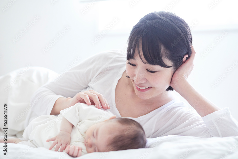 眠る赤ちゃんと添い寝をする母親 眠る赤ちゃんと添い寝をする母親