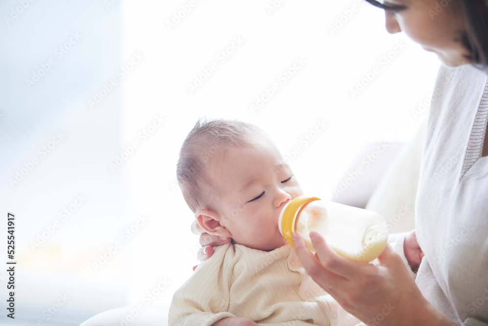 赤ちゃんを抱っこする母親とミルクを飲む赤ちゃん 赤ちゃんを抱っこする母親とミルクを飲む赤ちゃん