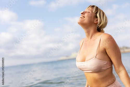 Beautiful woman swimming in the ocean. Smiling blonde girl enjoy in sunny day.
