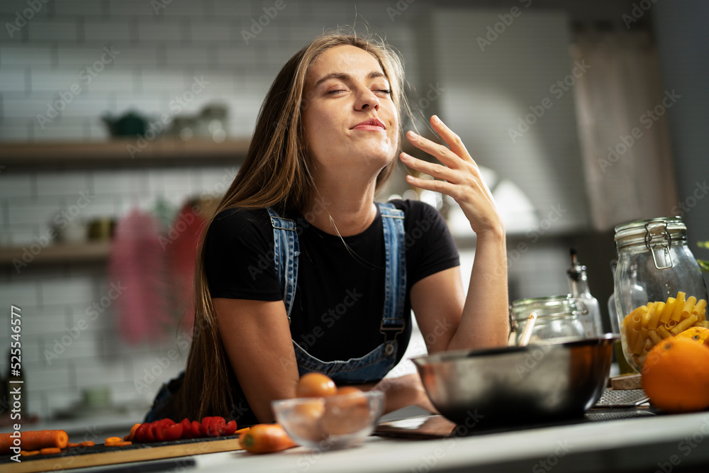 Young woman in kitchen. Beautiful woman making delicious food.