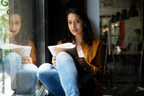 Young businesswoman drinking coffee in her office. Woman enjoy in coffee break