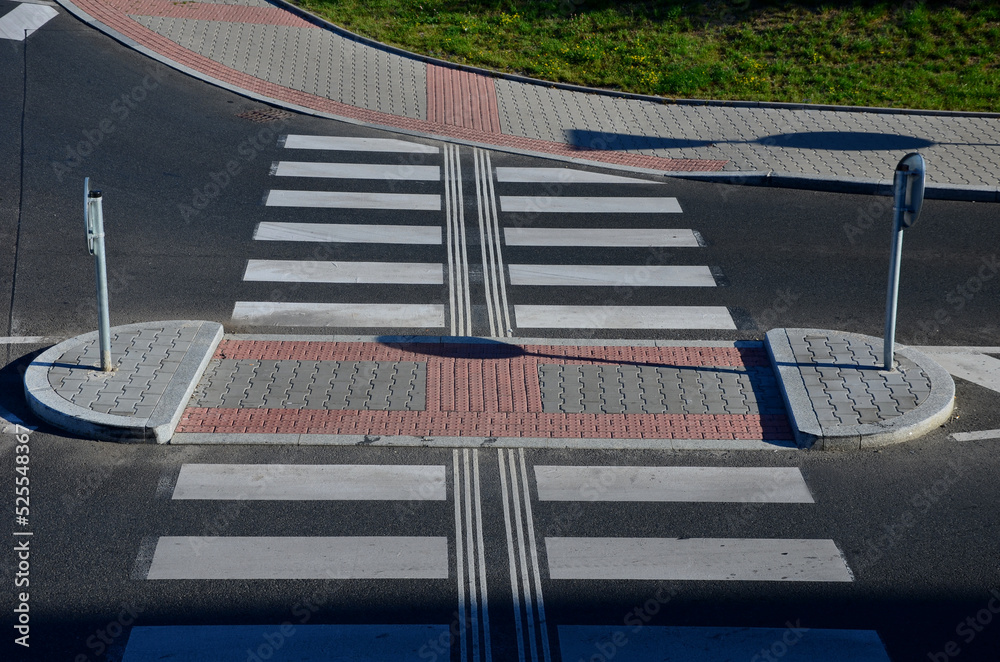 directionally divided lanes at intersection. crossing has a raised safety island for pedestrians