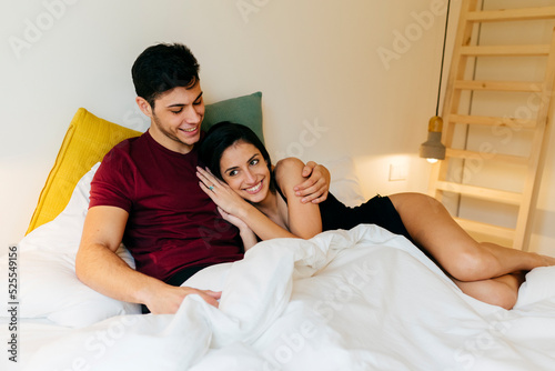 Couple cuddling on bed