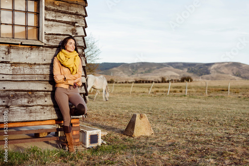 Stylish woman on ranch standing in a wooden cabin photo