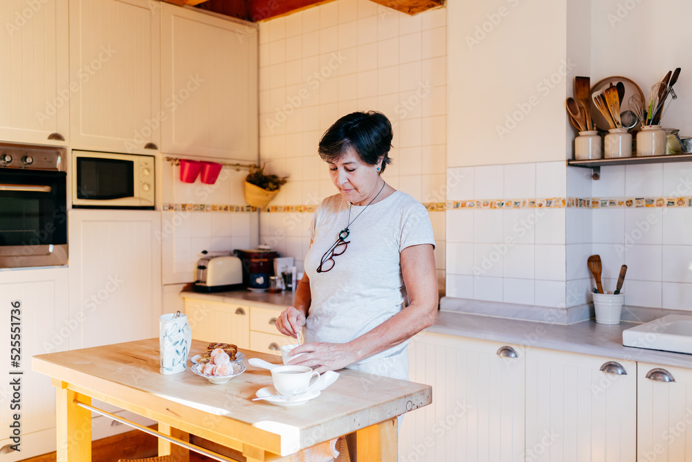 Mature woman preparing breakfast in home kitchen Mature woman preparing breakfast in home kitchen