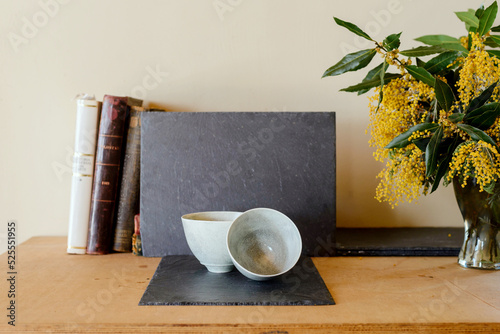 Crockery on table with books and bouquet of flowers photo