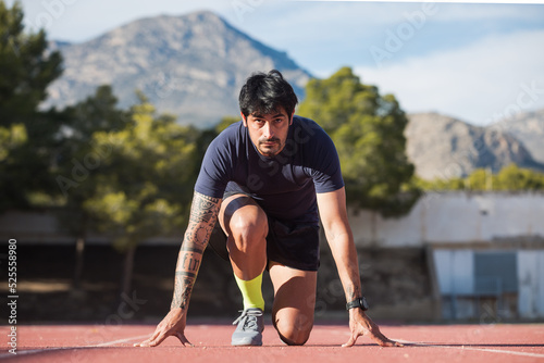 Sportsman in crouch start position at stadium