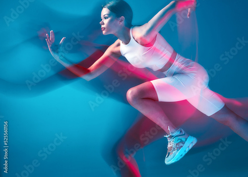 Fototapeta Naklejka Na Ścianę i Meble -  Endurance running. Female athlete run at high speed in pink neon light. Motion blur. Athletic modern girl runner
