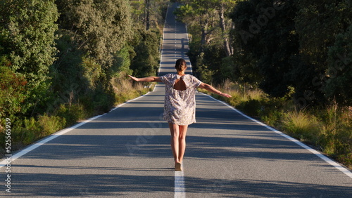 Mujer andando sobre lineas de carretera