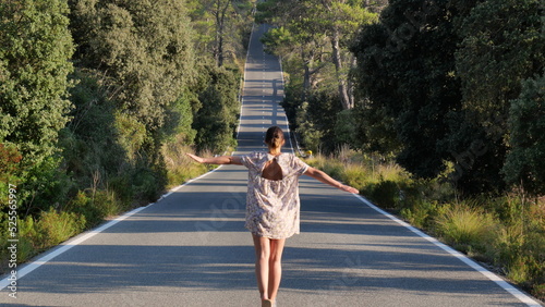 Mujer andando sobre lineas de carretera