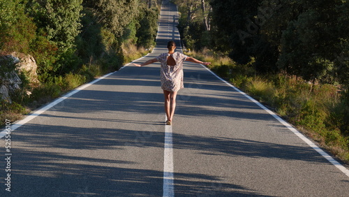 Mujer andando sobre lineas de carretera