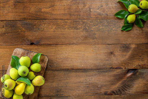 Wooden background. Ripe pears with green leaves on a wooden background. Place for text. Copy space.