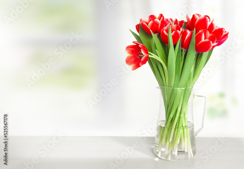 Red tulips in vase on table empty copy space. Spring flowers.Mother's day. Women's day. Holiday flowers bouquet gift.