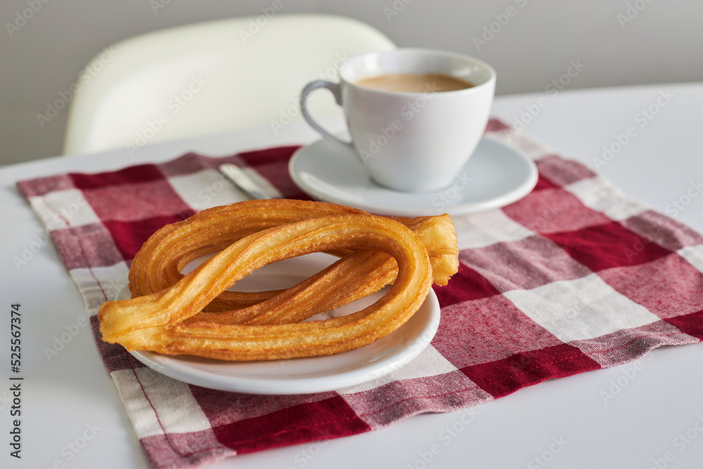 Crunchy churros and mug of coffee on table Crunchy churros and mug of coffee on table