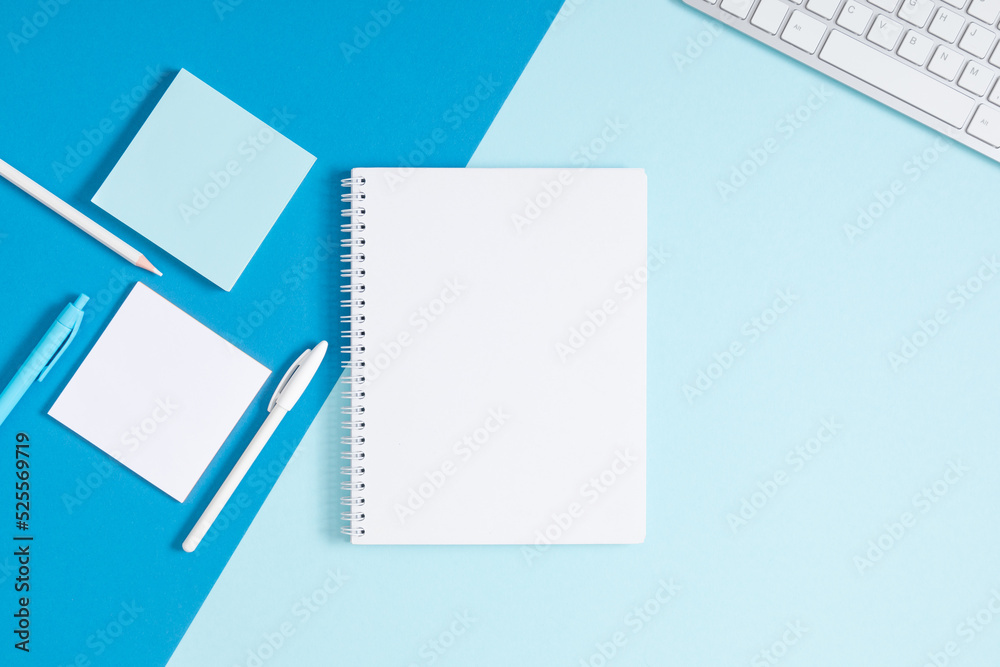 Business concept background. Flatlay, top view of photo of keyboard notepad pencil blank notes stationery on isolated blue table desk background Business concept background. Flatlay, top view of photo of keyboard notepad pencil blank notes stationery on isolated blue table desk background