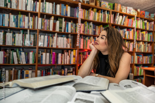 a young smart student is studying useful and interesting in a beautiful old library.