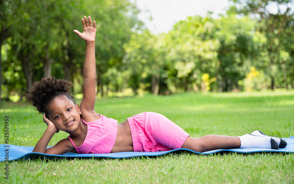 Happy yoga African American kid girl at garden	