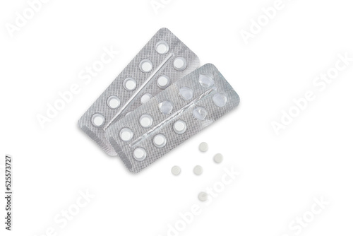 Two blisters with pills and five pills nearby on a white background