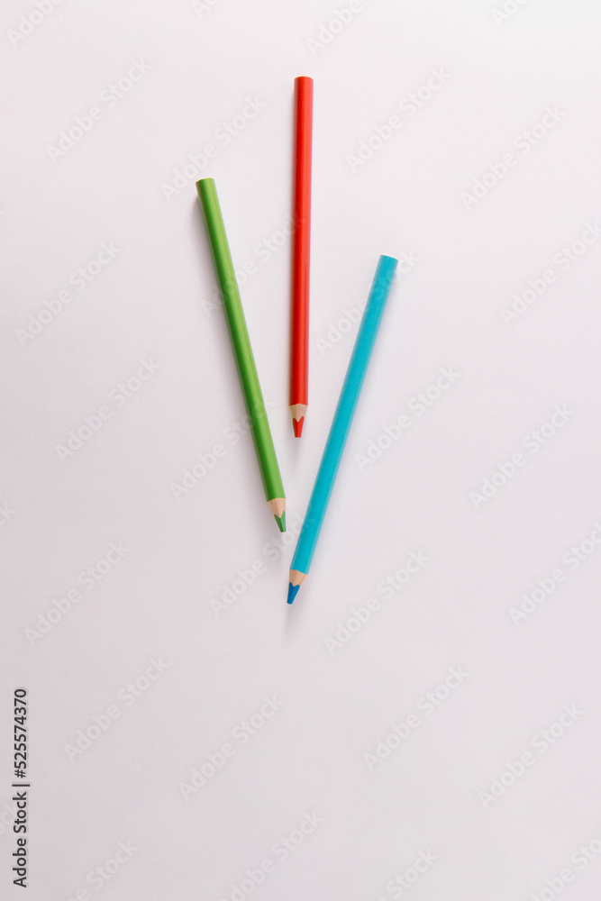 Colored wooden pencils on a gray background, minimal back to school concept, red, green, blue Colored wooden pencils on a gray background, minimal back to school concept, red, green, blue