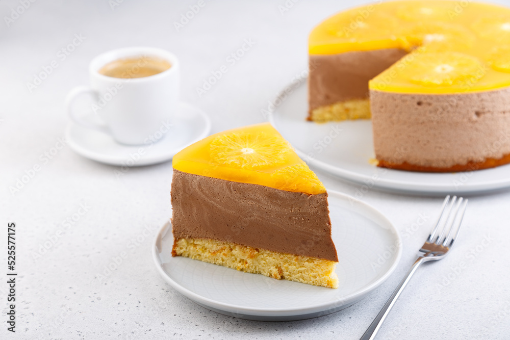 Chocolate-orange mousse cake with biscuit base, jelly and orange circles. Piece of homemade cheesecake and a cup of coffee. Traditional holiday dessert. Selective focus, close-up. Chocolate-orange mousse cake with biscuit base, jelly and orange circles. Piece of homemade cheesecake and a cup of coffee. Traditional holiday dessert. Selective focus, close-up.