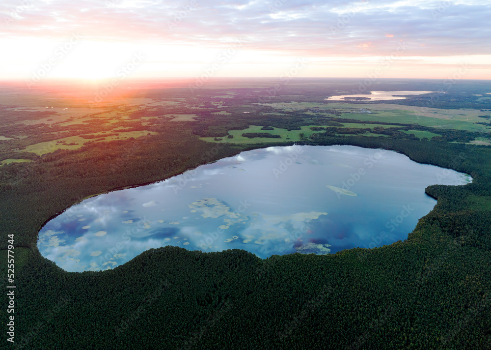 Lake in forest at sunset. Sunset over the forest lake. Freshwater Lakes. Water supply problems and water deficit, ecology and environmental. Pond in forest on sunset, aerial view. Wet Pond water.