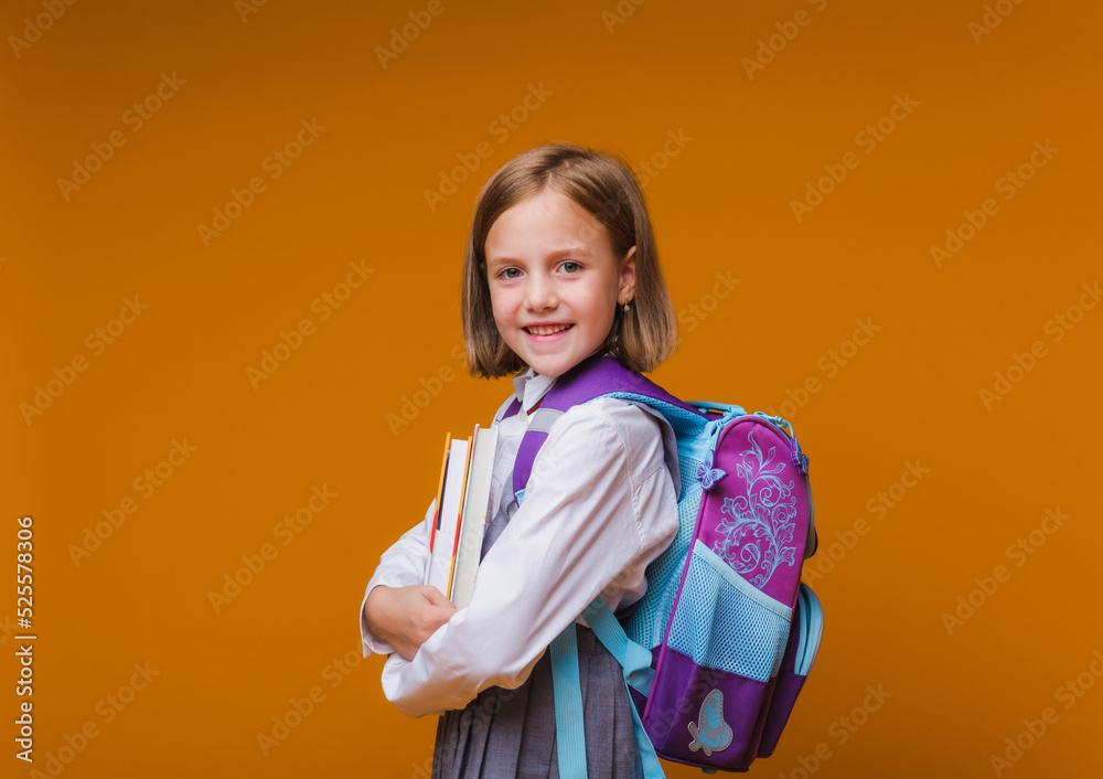 Back to school. A schoolgirl with a school bag backpack on an isolated studio background. The concept of school and education. A teenage girl in a school uniform. Back to school. A schoolgirl with a school bag backpack on an isolated studio background. The concept of school and education. A teenage girl in a school uniform.