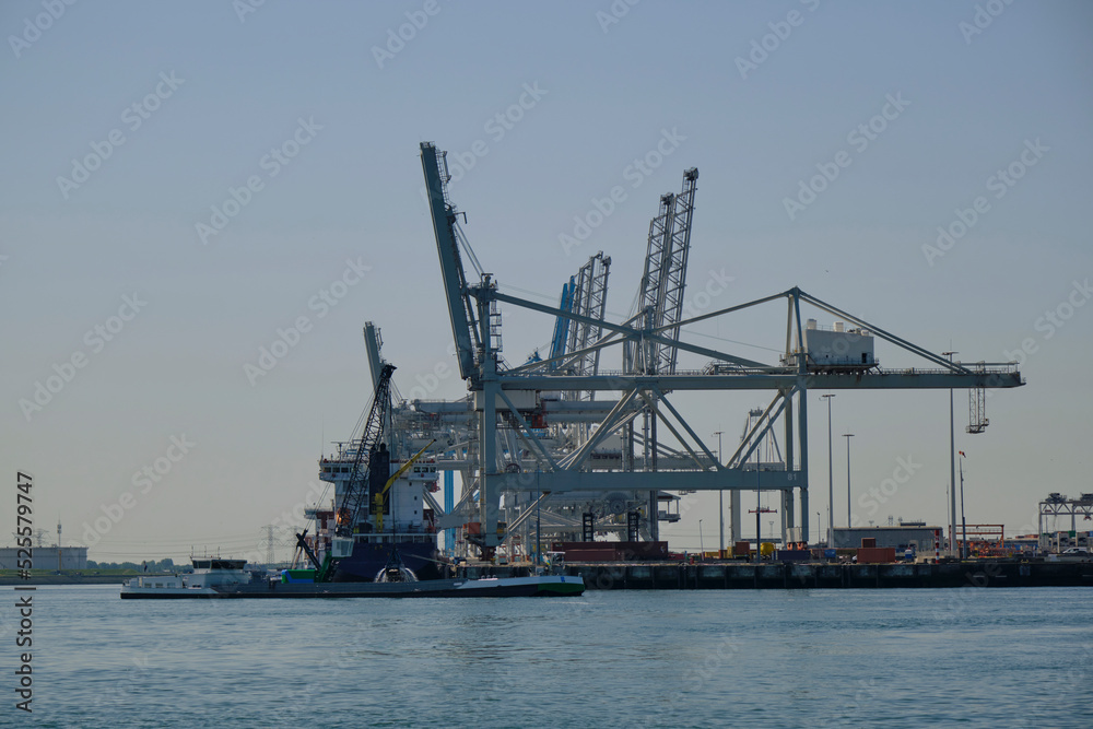 ROTTERDAM, THE NETHERLANDS - New container terminal with a very large container ship and in the foreground a smaller inland container ship on the Maasvlakte of the port of Rotterdam