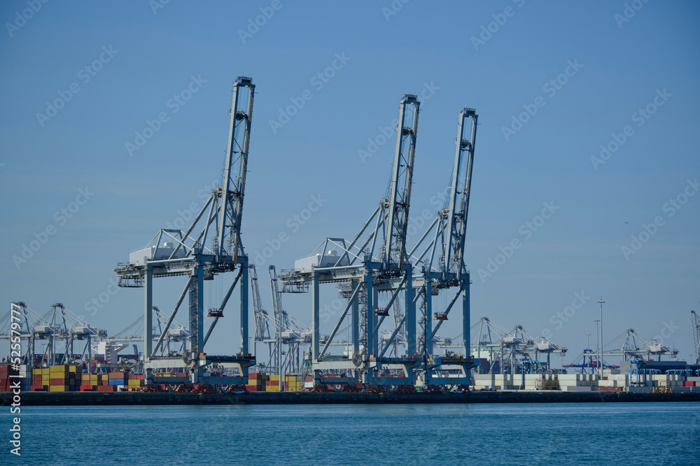 ROTTERDAM, THE NETHERLANDS - New container terminal with a very large container ship and in the foreground a smaller inland container ship on the Maasvlakte of the port of Rotterdam ROTTERDAM, THE NETHERLANDS - New container terminal with a very large container ship and in the foreground a smaller inland container ship on the Maasvlakte of the port of Rotterdam