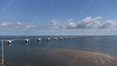 View on longest bridge in the Netherlands, Zealand bridge spans Eastern Scheldt estuary, connects islands Schouwen-Duiveland and Noord-Beveland in province of Zeeland, water of Oesterschelde and boats photo