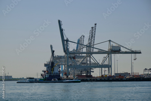 ROTTERDAM, THE NETHERLANDS - New container terminal with a very large container ship and in the foreground a smaller inland container ship on the Maasvlakte of the port of Rotterdam