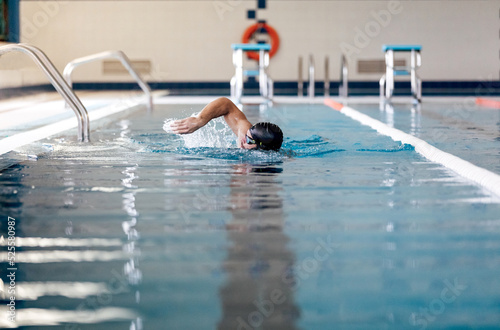 Sportsman swimming in pool with lane divider