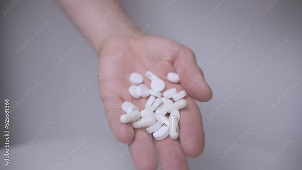 white pills and capsules fall out of hand slow mo white pills and capsules fall out of hand slow mo