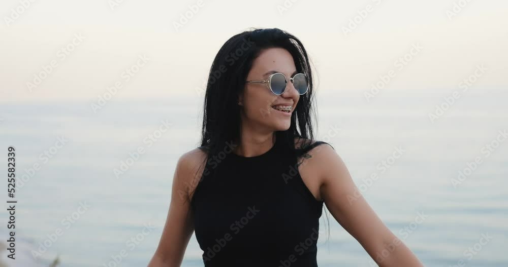 Smiling woman in the braces on her teeth at the sea view Smiling woman in the braces on her teeth at the sea view