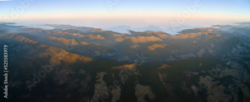 Beautiful mountain panoramic landscape with hazy peaks and foggy valley at sunset
