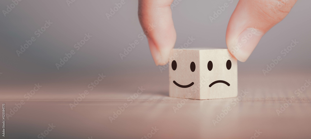 Emotional state and Mental health concept. Hand hold happy smile positive feeling face bright side and sad feeling negative face icon on wood cube block for choice mindset. With copy space for text. Emotional state and Mental health concept. Hand hold happy smile positive feeling face bright side and sad feeling negative face icon on wood cube block for choice mindset. With copy space for text.