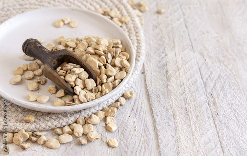 Scoop of raw dry Grass pea close up on wooden table. Legumes known in Italy as Cicerchia photo