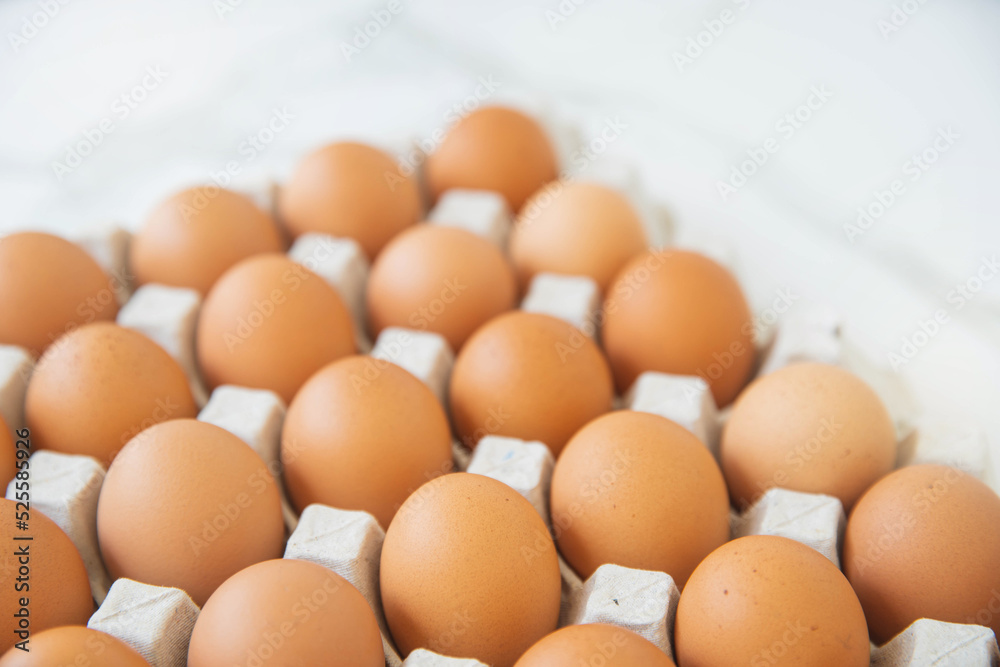 Close-up view of raw chicken eggs in egg box on wooden background. Raw chicken eggs in egg box organic food for good health high protein . Close-up view of raw chicken eggs in egg box on wooden background. Raw chicken eggs in egg box organic food for good health high protein .