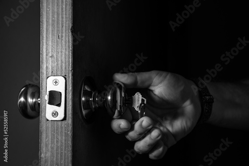 Hand opening a door. Entering from a dark room.