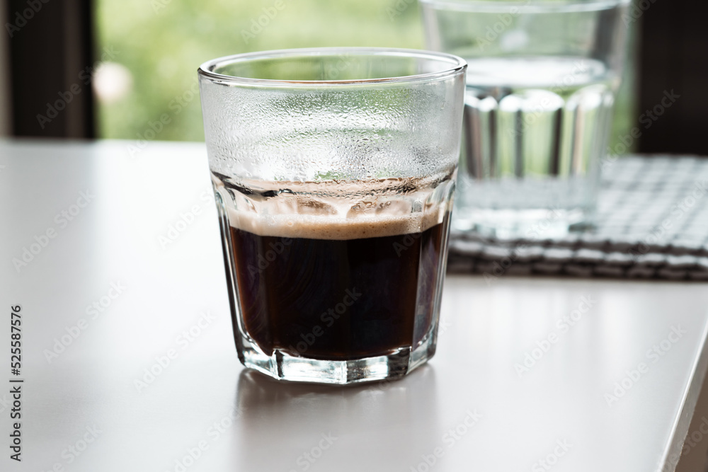 Fresh espresso and glass with water on white table background Fresh espresso and glass with water on white table background