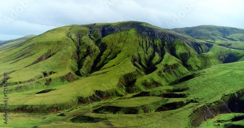  Medium close up shot of hills and ridges coated with green grass.