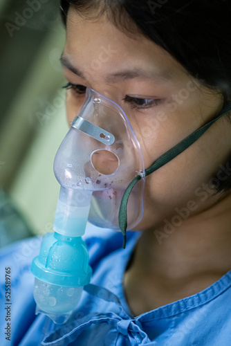 Close up sick Yong asian girl with face oxygen mask,on bed in hospital, Healthcare workers in the Coronavirus Covid19 pandemic