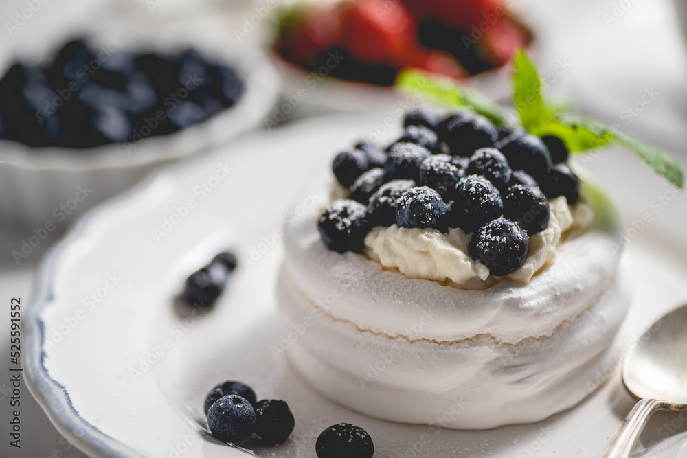 Delicious mini Pavlova meringue nest with blueberry and mint leaves Delicious mini Pavlova meringue nest with blueberry and mint leaves