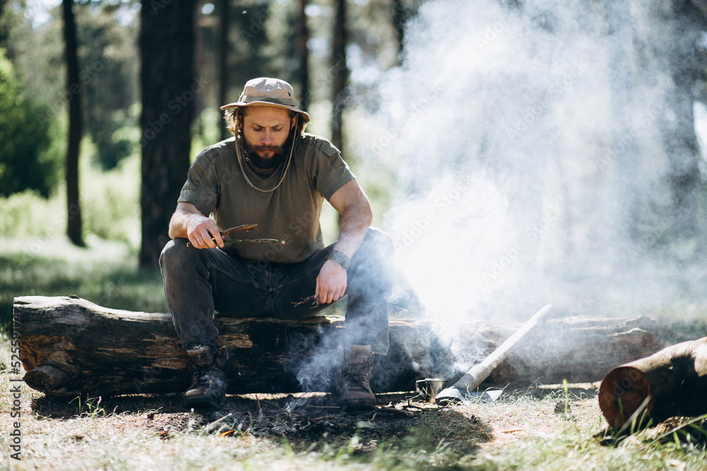 Tourist by bonfire in forest Tourist by bonfire in forest