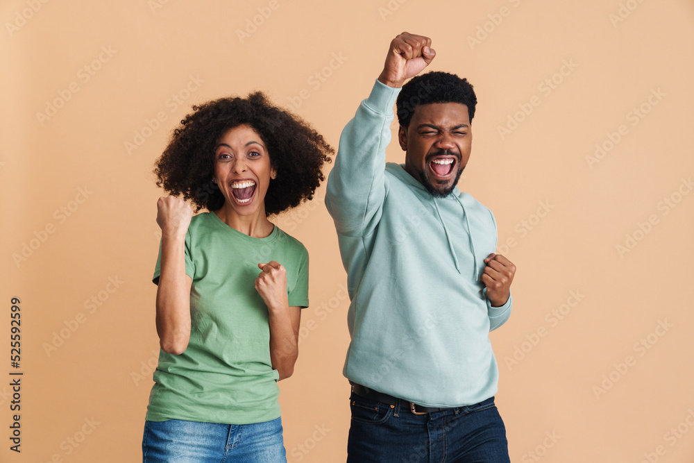 Black man and woman laughing and gesturing as winners Black man and woman laughing and gesturing as winners