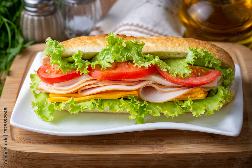 Cheese, ham, lettuce and tomato slices in an appetizing tasty sandwich. Cheese, ham, lettuce and tomato slices in an appetizing tasty sandwich.