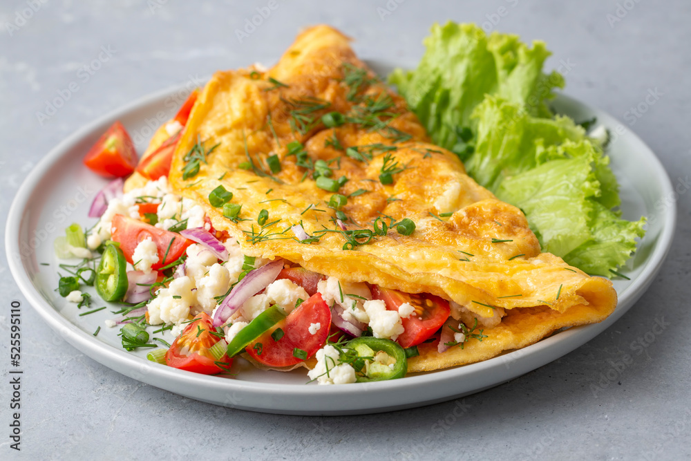 Omelet breakfast with cherry tomatoes and white feta cheese on white Omelet breakfast with cherry tomatoes and white feta cheese on white